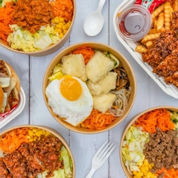 The image is of a table full of delicious and healthy Korean food, including Bibimbap and Deep Fried Chicken. The spread includes a variety of dishes and ingredients.