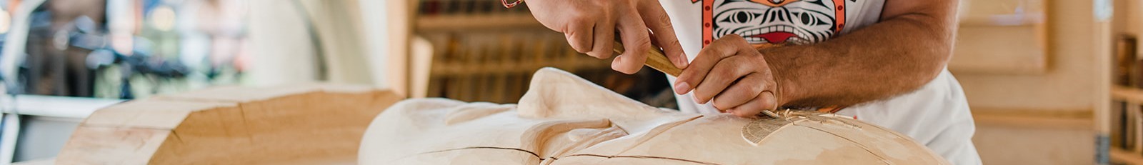 The image shows a person's hands on a white cloth, and the additional context mentions a carver working with wood.