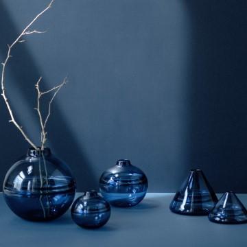 The image features a group of glass vases filled with water in a still life composition. The setting appears to be indoors, possibly at Dougherty Glassworks.