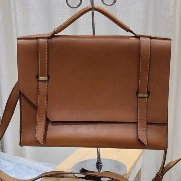 The image shows a brown leather purse on a stand indoors. It is a Jayna leather craft bag.