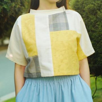 The image shows a person wearing a yellow and blue skirt. It is a casual outfit from the Uni Design clothing brand.