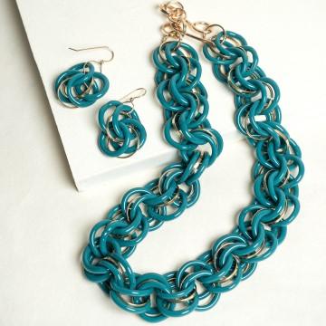 The image is a set of earrings designed by Minori Takagi. The earrings are made of turquoise beads and feature a teal color. The tags associated with the image include fashion accessory, jewelry, bead, and chain.