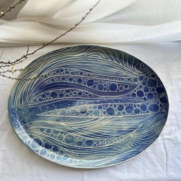 The image is a blue and white plate from Blue Poppy Pottery, made of ceramic porcelain. It is a serving tray for indoor use.