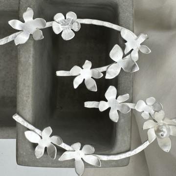The image is a close-up of white flowers earrings. It is tagged as a flower and is related to Soma Mo jewelry.