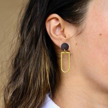 The image shows a close-up of a woman's ear with a black earring. The woman is wearing a fashion accessory designed by Billy Would Designs.