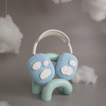 The image shows a pair of blue ear buds designed as ggümm studio headphones protectors. The photo is tagged as a toy, still life photography, indoor, handmade, and earmuff.