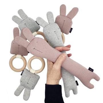 The image is of a hand holding baby toys. It is a baby toy featuring a rabbit cartoon-like design. 